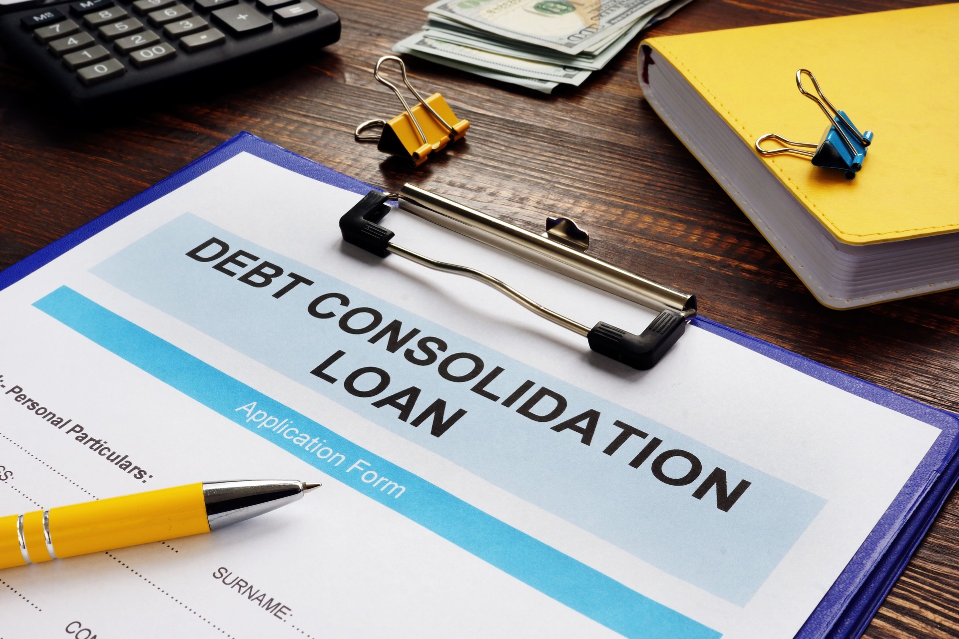 Debt consolidation loan, notepad and calculator.